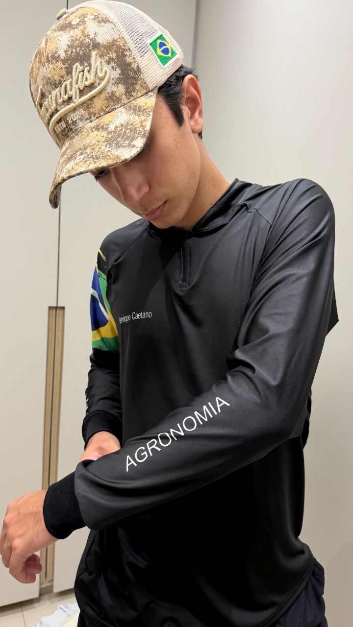 Estudante vestindo camisa preta TucunaFish com zíper, personalizada com nome e Agronomia na manga