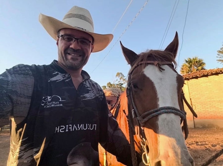 Fazendeiro de chapéu ao lado do cavalo vestindo camisa TucunaFish