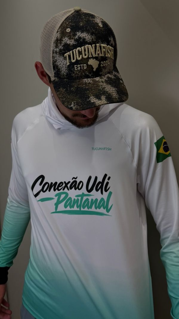 Pescador vestindo camisa de pesca masculina TucunaFish com capuz, personalizada com o logo Conexão Udi Pantanal
